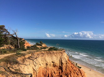 Blick über eine felsige Klippe an der Felsalgarve hinaus aufs Meer