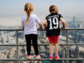 Zwei Kinder blicken von oben über die Skyline von Dubai